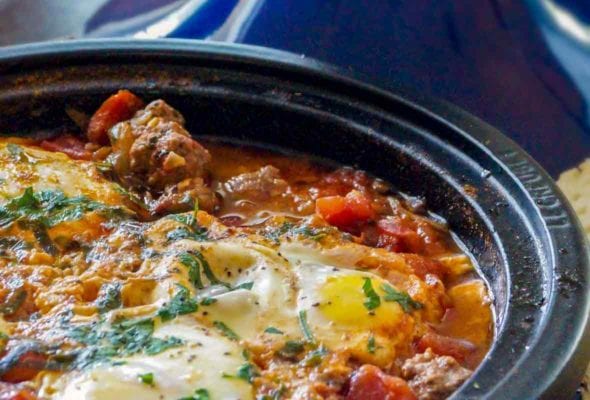 Kefta Mkaouara, or Moroccan meatball-tomato-and-egg tagine, in a blue pot sprinkled with parsley