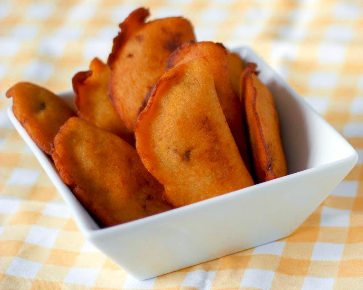A square bowl of deep-fried pastel com diabo dentro--or pastry with the devil inside--on a yellow-checked tablecloth