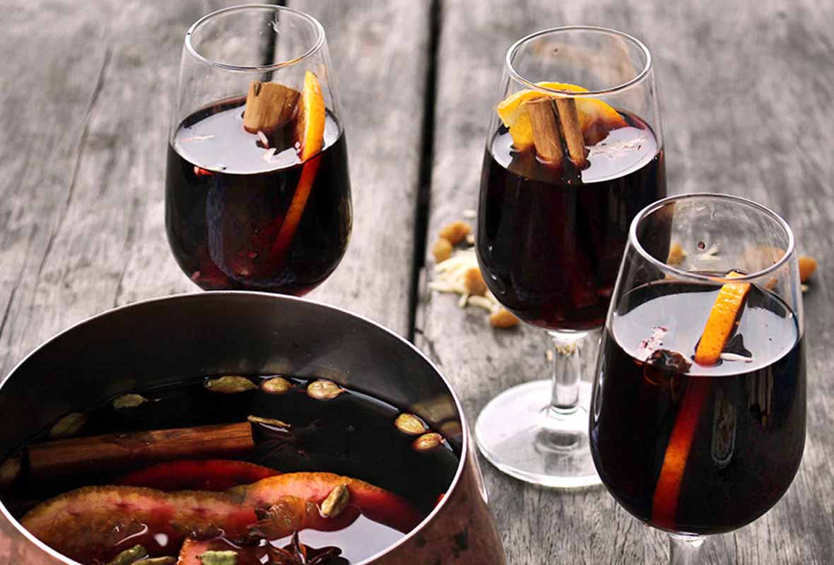 Three glasses of glogg (mulled wine) with orange slices and cinnamon sticks