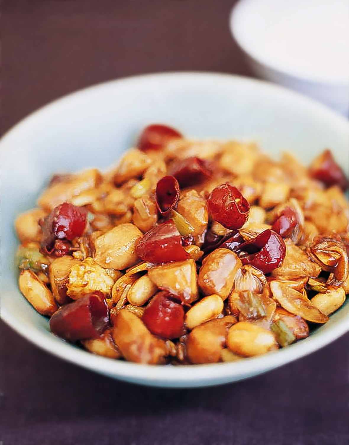 Bowl of chicken pieces, peanuts, chiles in an Authentic Chinese sauce of soy, sesame oil, black vinegar