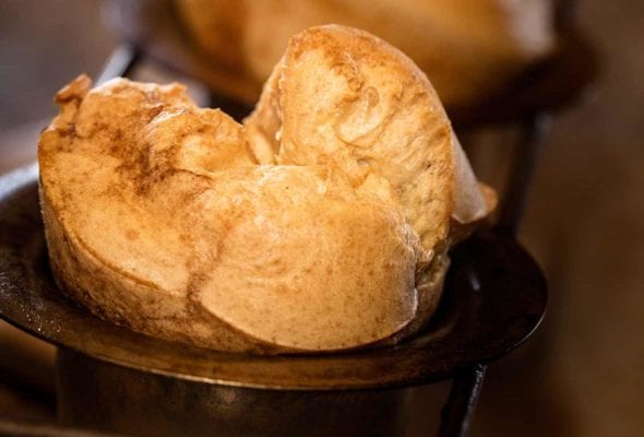 A popover with strawberry butter in a popover tin.
