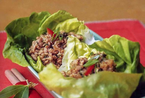 Butter lettuce leaves cradling ground dark chicken in bowl