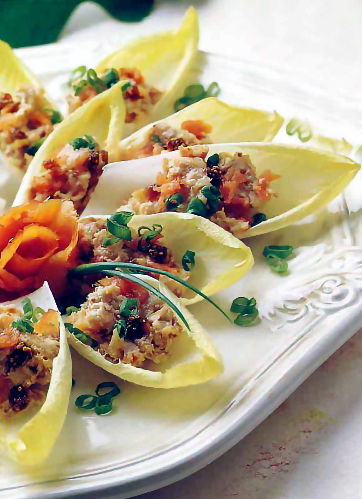 Endive leaves stuffed with cream cheese spread with smoked salmon with chopped chives on top