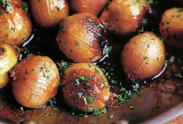 A skillet filled with Ina Garten's caramelized shallots, sprinkled with parsley.
