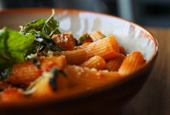 A skillet filled with rigatoni with tomatoes, eggplant, and mozzarella.