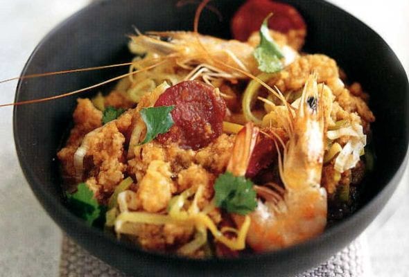 Black bowl of Portuguese bread soup--called acorda--with shrimp, sausage, tomatoes, garlic, cilantro