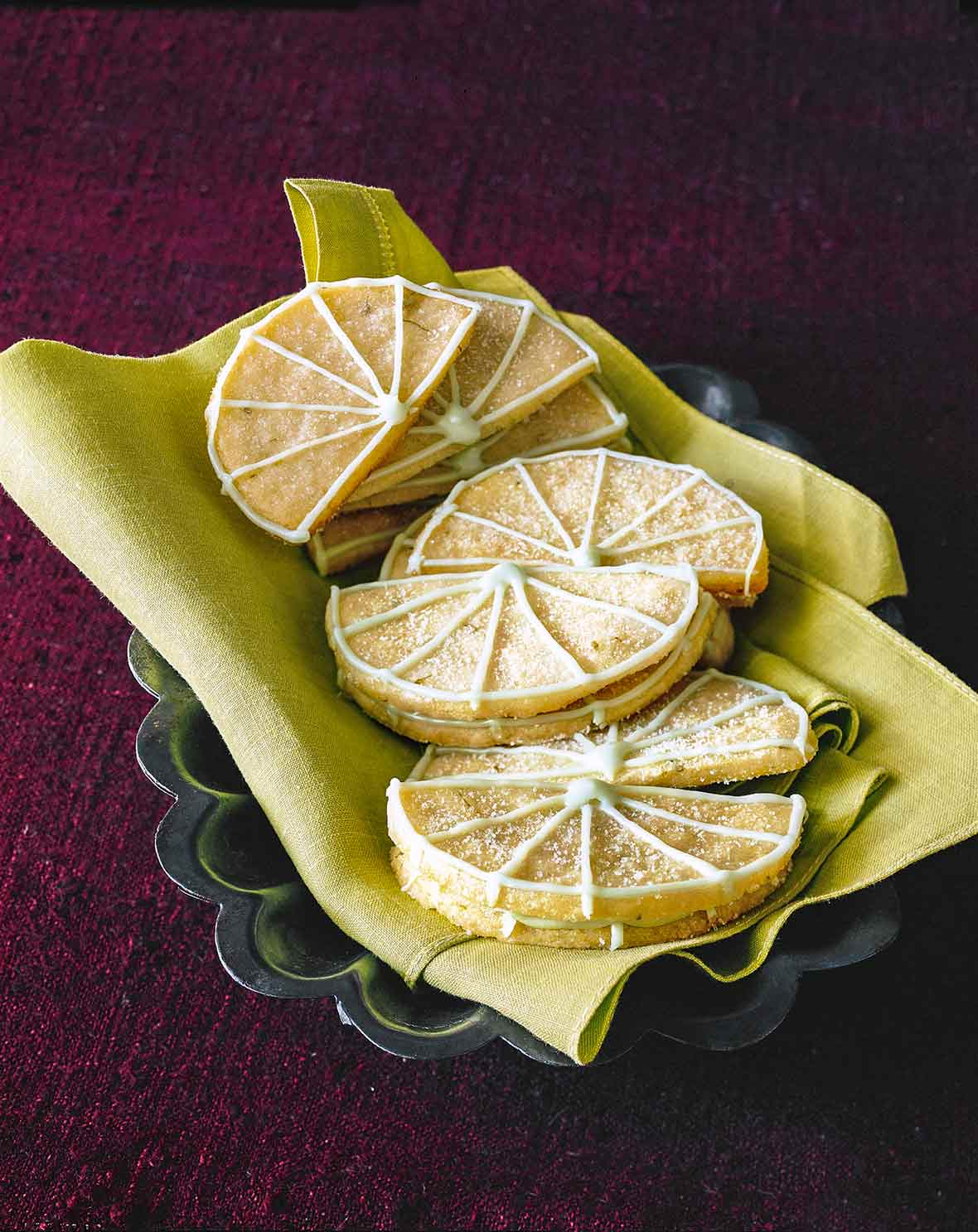 12 Key lime sugar cookies in the shape of lime wedges with lime icing