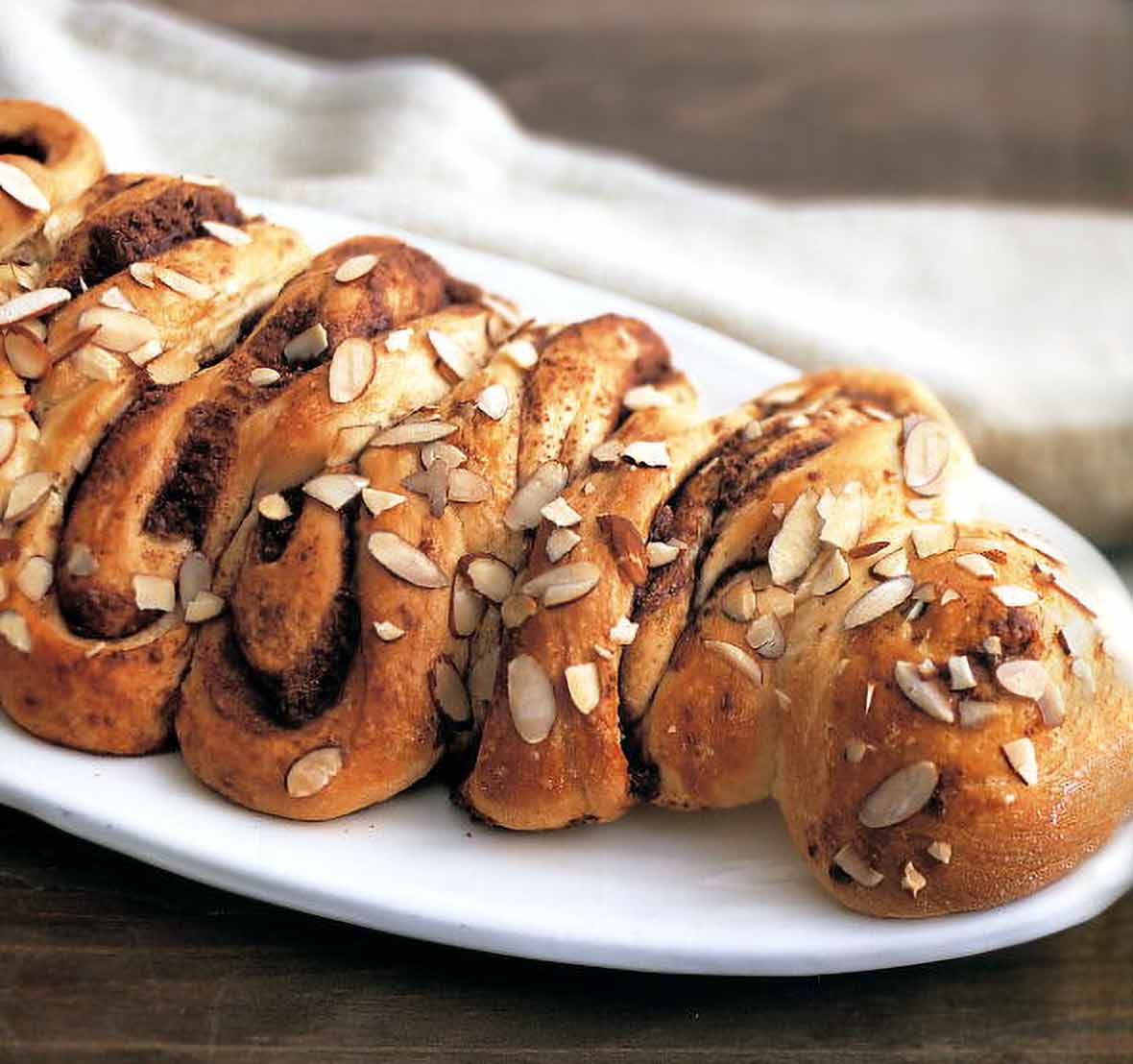 Danish chocolate-streusel coffee cake with chocolate filling and slivered almonds topping on a white plate