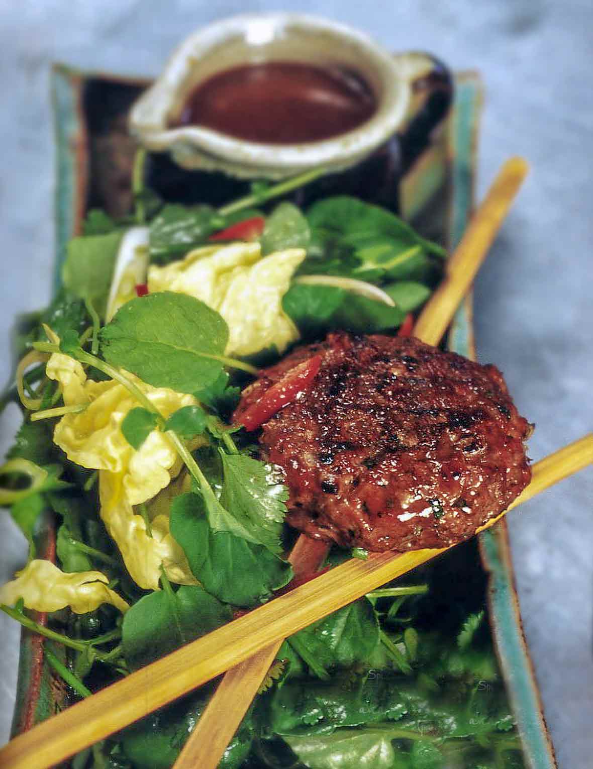 A spiced lamb burgers on a Vietnamese salad of watercress, scallions, mint, basil, cilantro