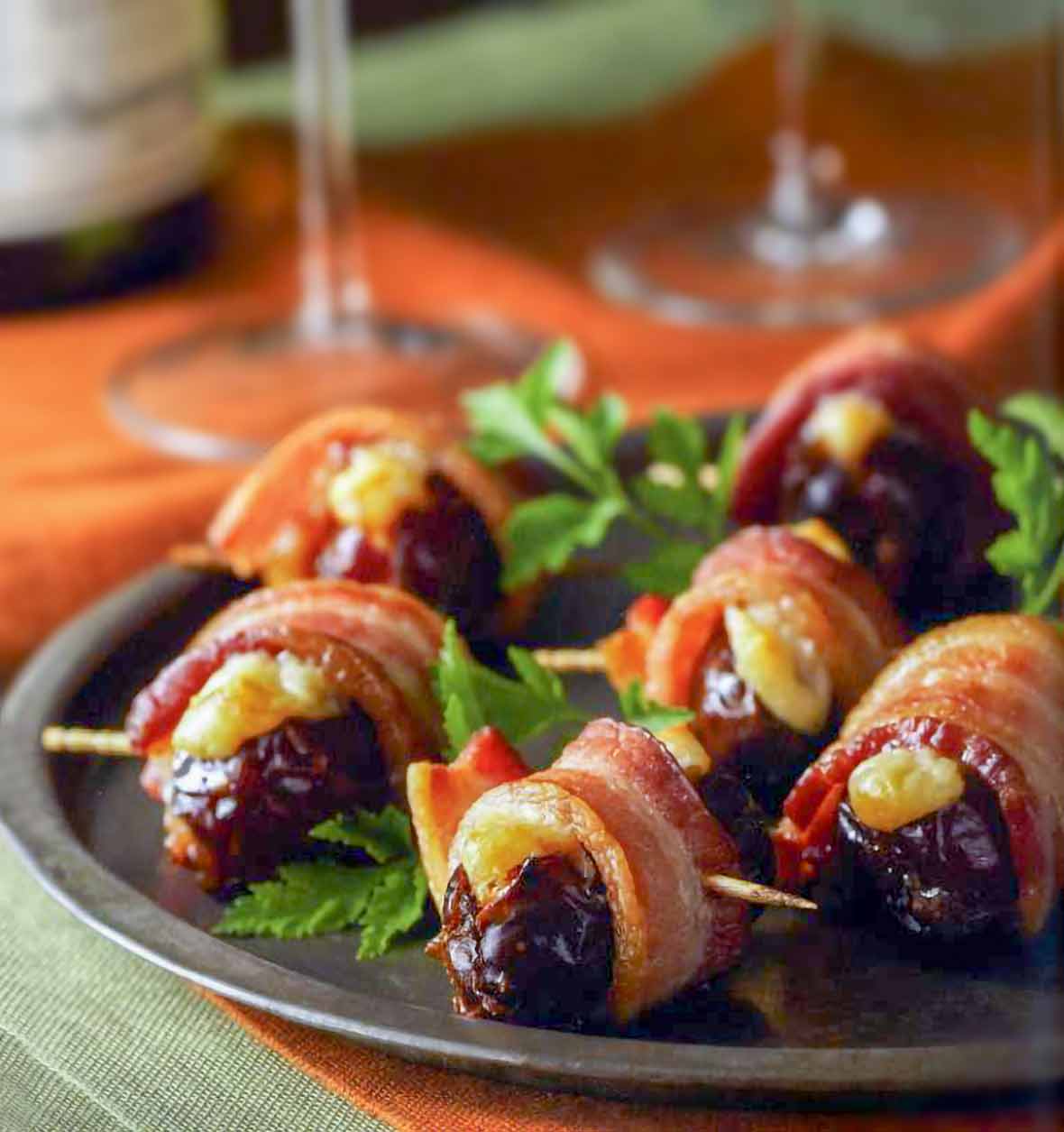 Plate of crispy bacon-wrapped stuffed dates held by toothpicks, parsley garnish