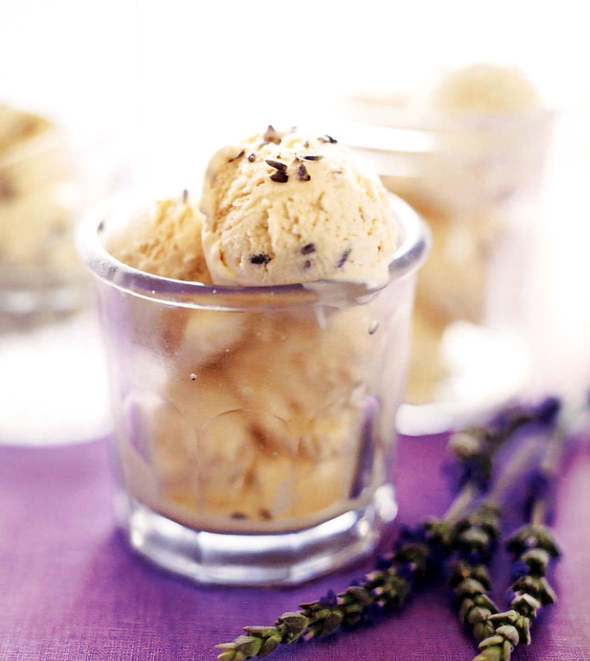Glass of lavender honey ice cream, in a purple cloth with lavender sprigs