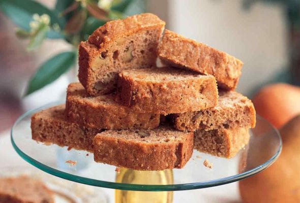 A glass cake stand topped with several slices of Cornelia Walker Bailey's pear bread.