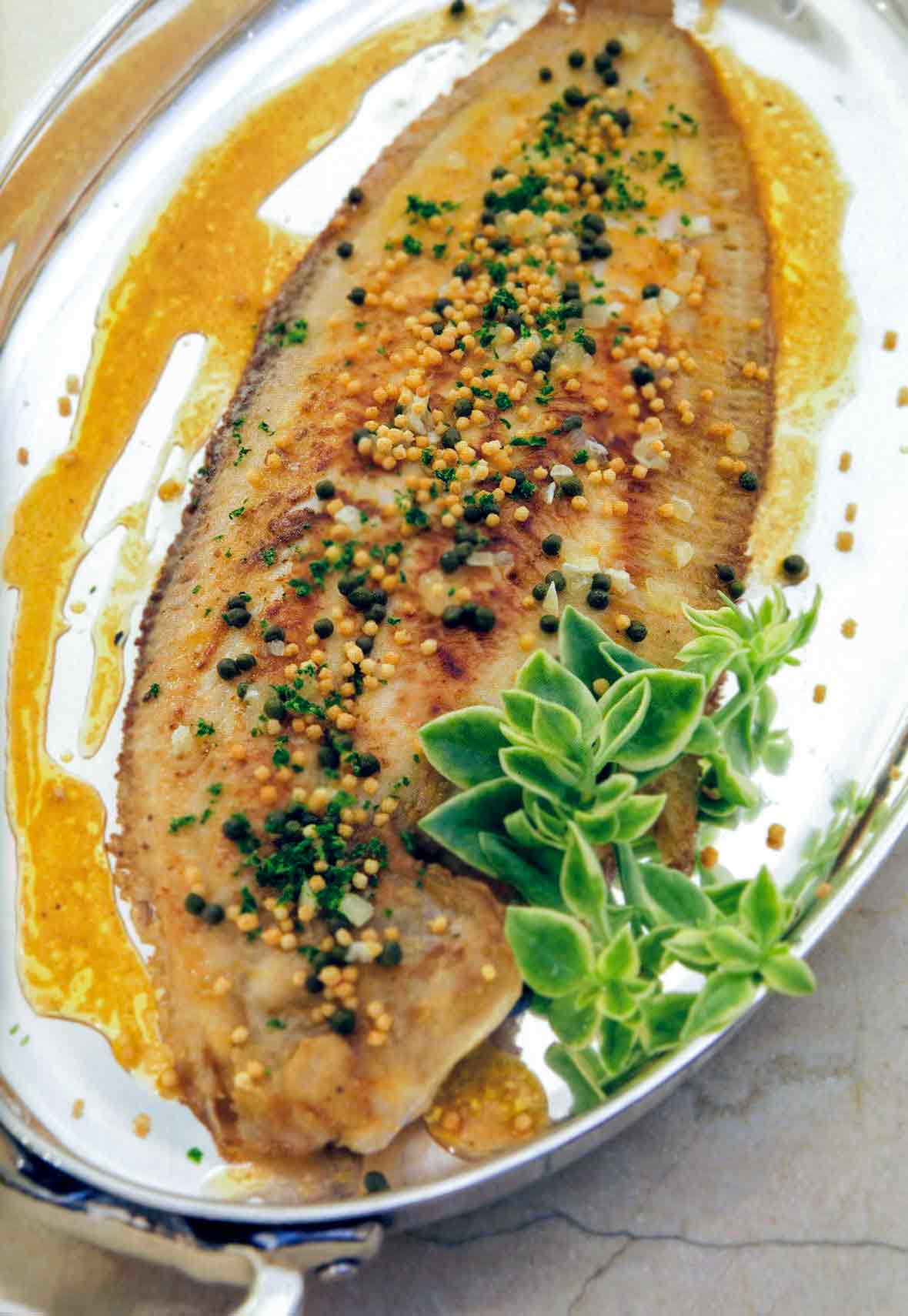 Sole fillet lightly pan fried in butter and olive oil, topped with capers, lemon, minced parsley and croutons