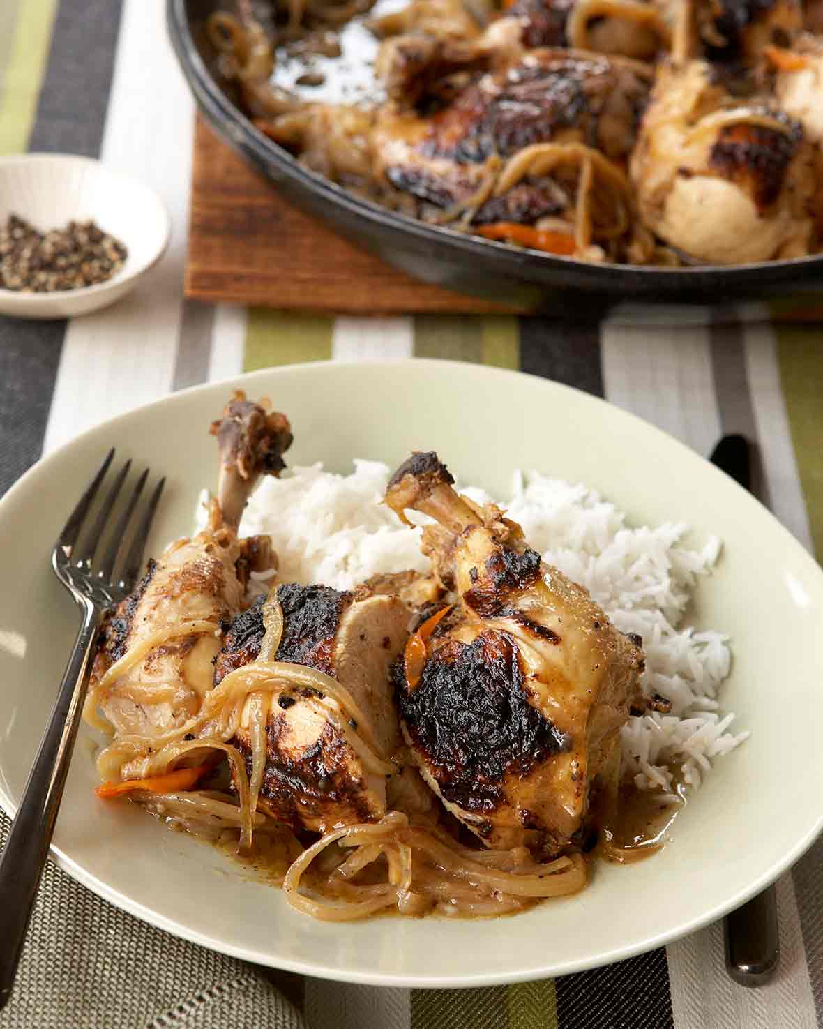 Plate of Senegalese grilled chicken legs and thighs cooked with onions and lemon, rice on the side