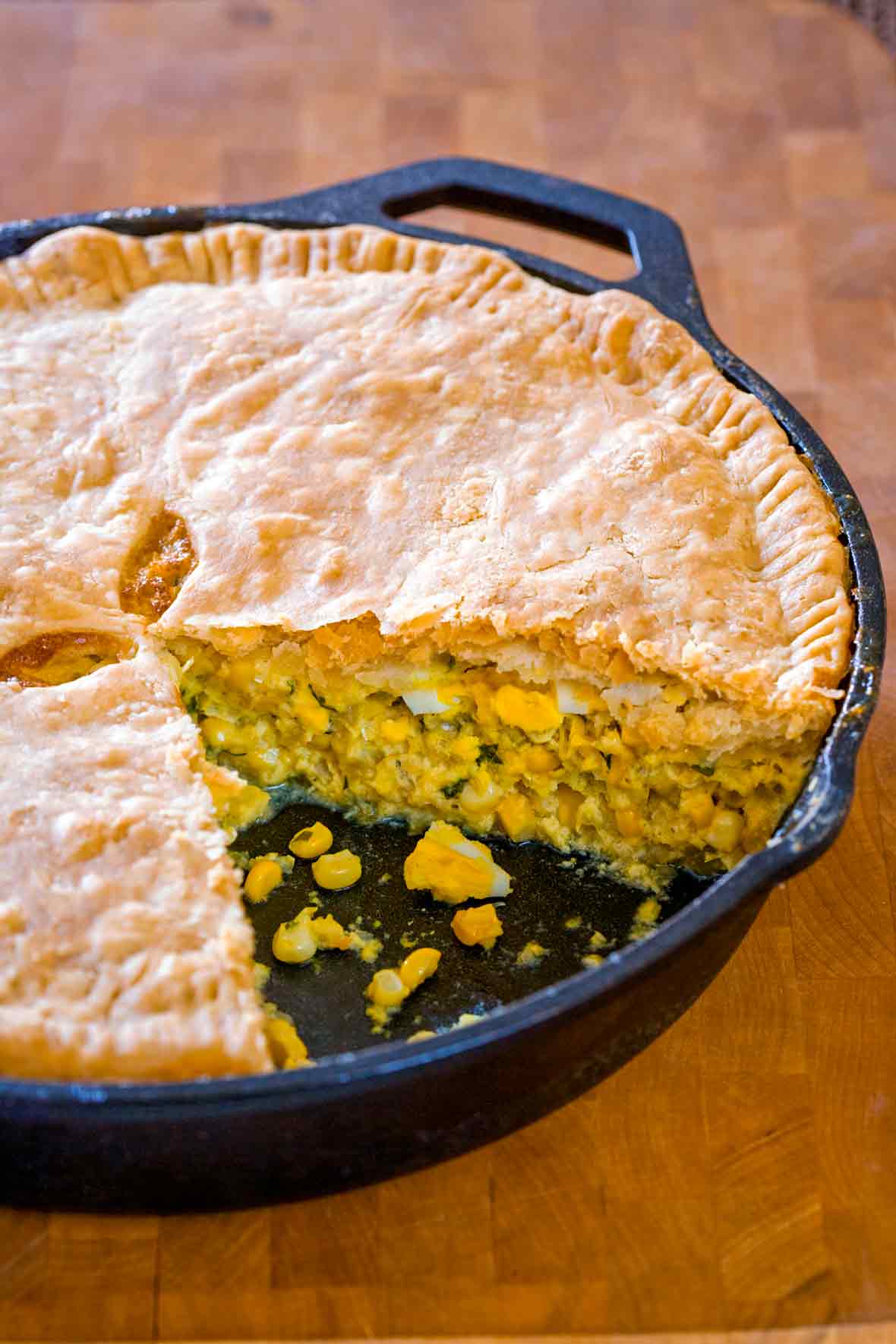 A corn pie, with a sliced remove, the filling of corn, egg, celery, onion, parsley can be seen