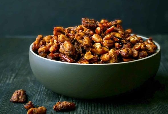 Roasted mixed nuts coated with sugar and spices in green bowl