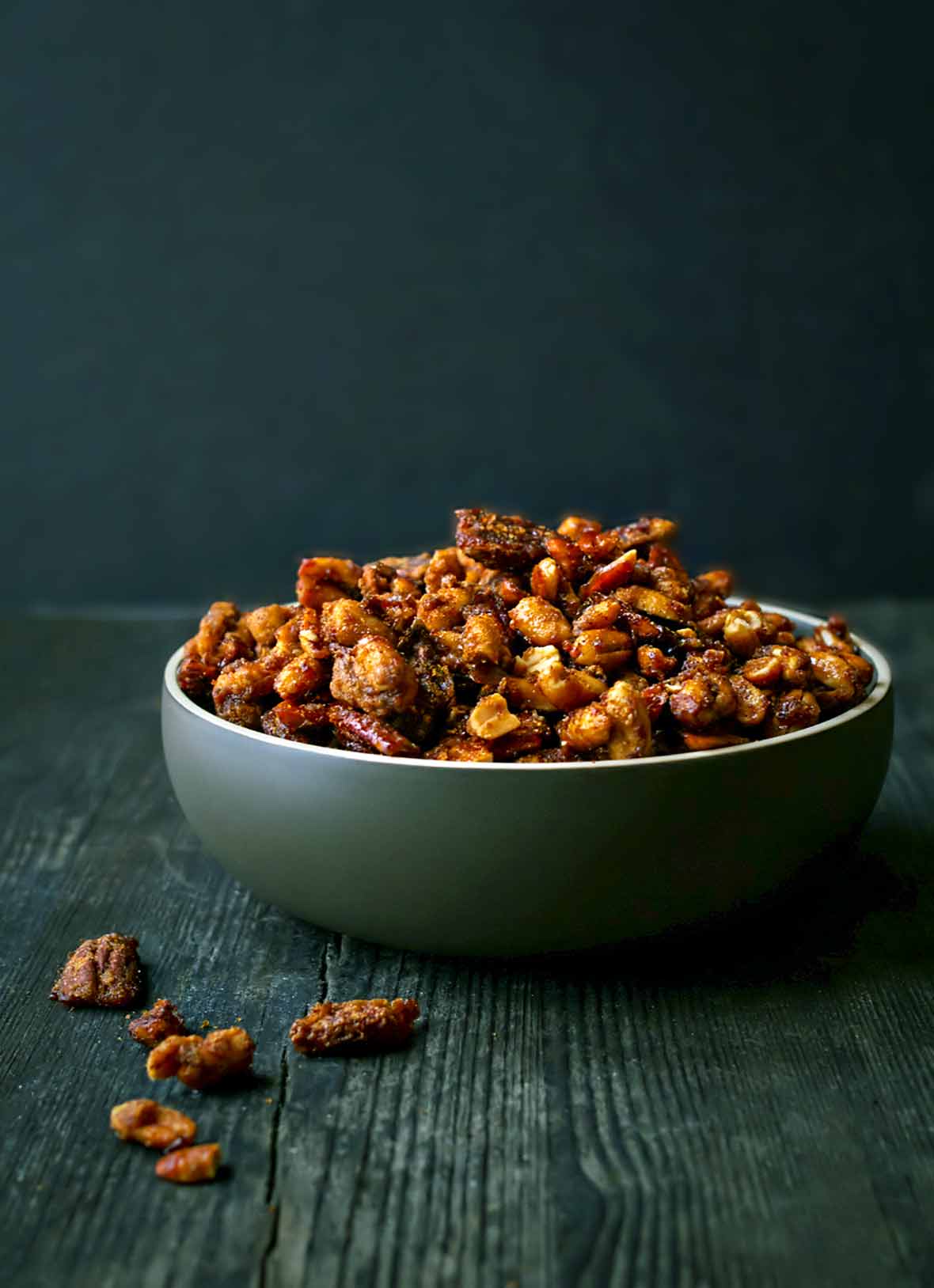 Roasted mixed nuts coated with sugar and spices in green bowl