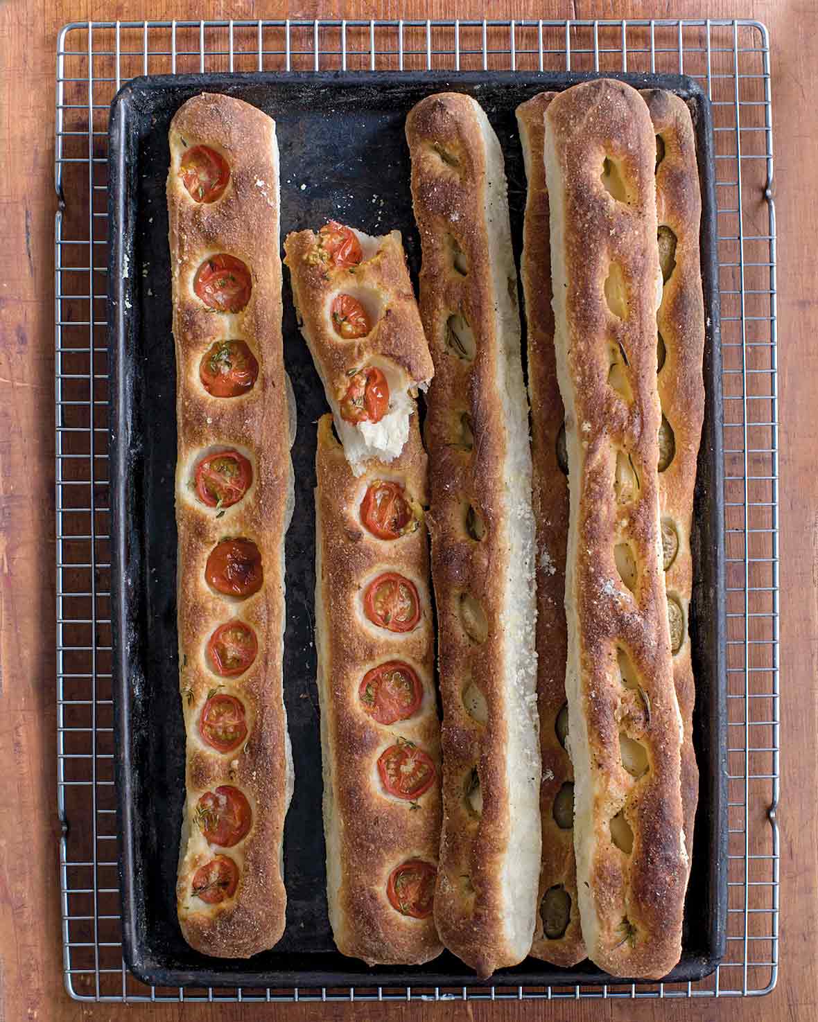 Five no-knead baguettes by Jim Lahey, some with sliced tomato, some with garlic and olives