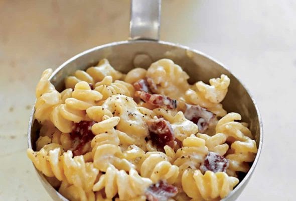A metal scoop filled with bacon-Cheddar macaroni and cheese.