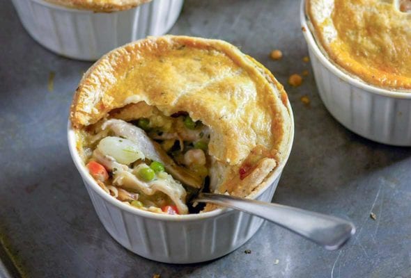 Four bowls filled with chopped chicken and vegetables all topped with golden crusts