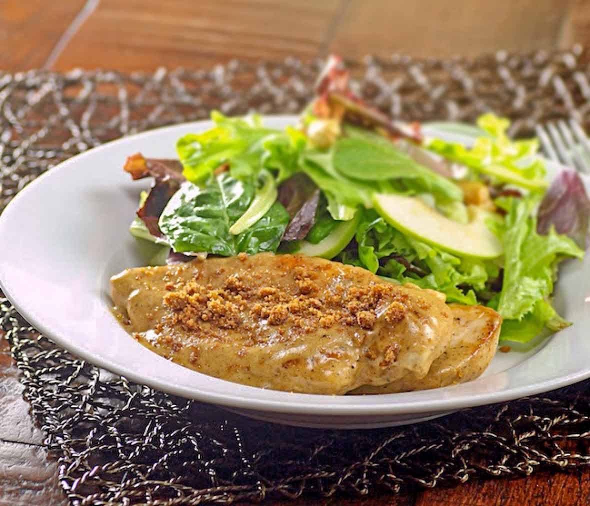 Cinnamon crunch chicken breast with a topping made from speculoos cookies, a salad behind