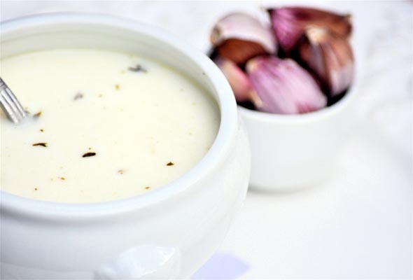 A soup bowl filled with French newlywed soup, and a small dish of shallots beside it.