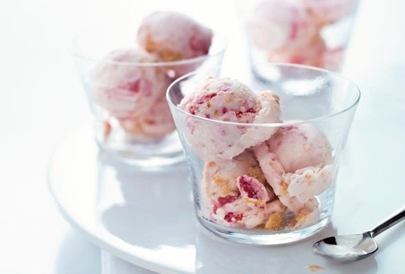 Three glass cups with scoops of strawberry cheesecake ice cream on a plate and dish towel