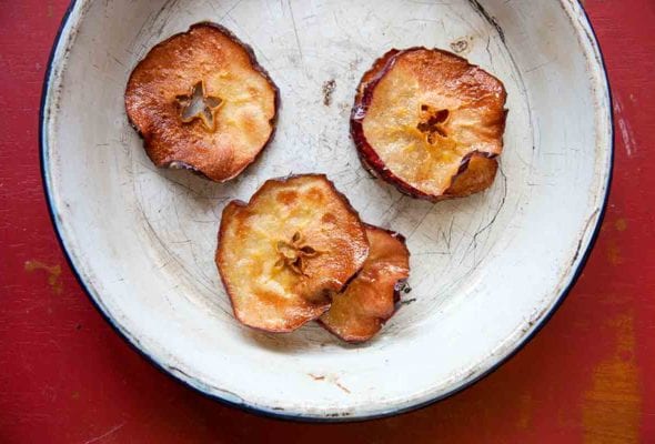 Four apple chips in a white pie dish.
