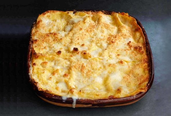 A cooked pumpkin lasagne in a square casserole dish.