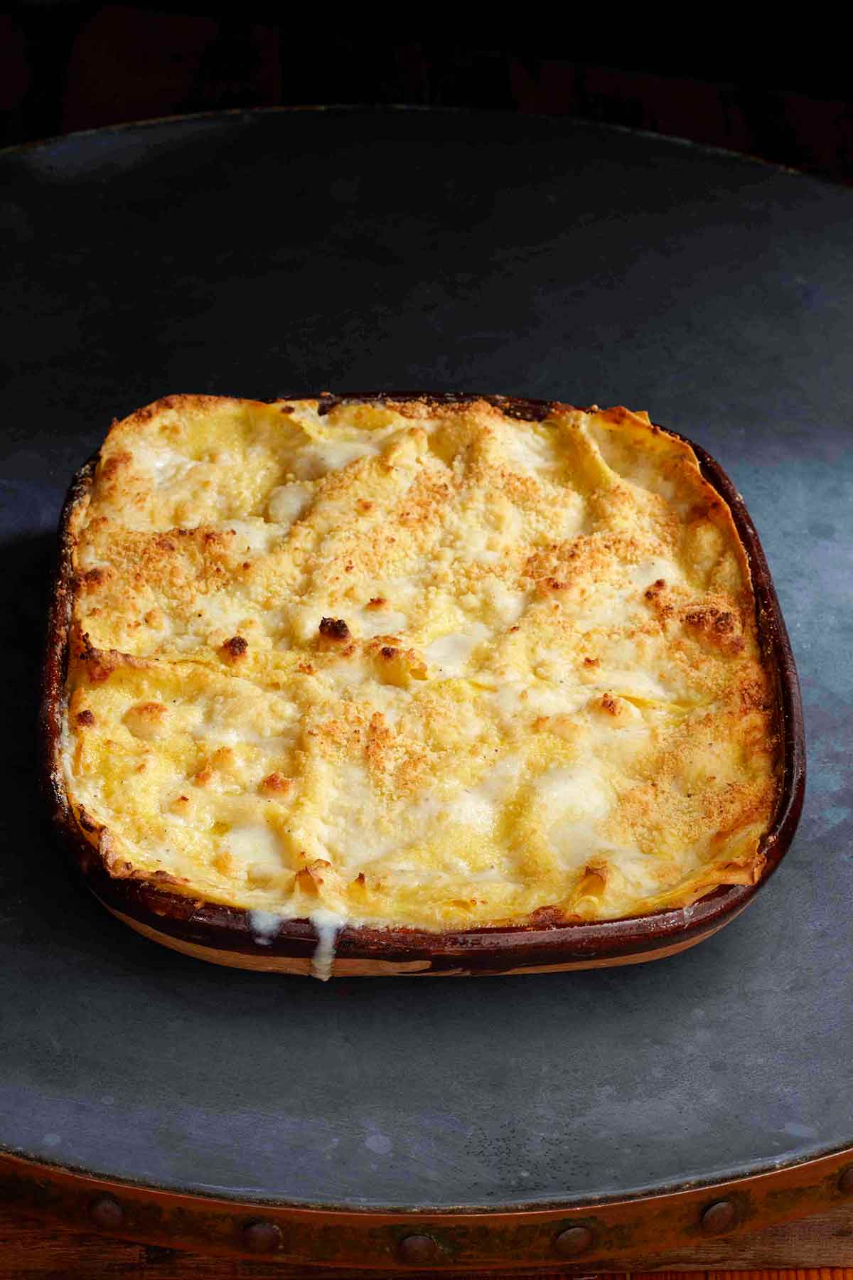 A cooked pumpkin lasagne in a square casserole dish.