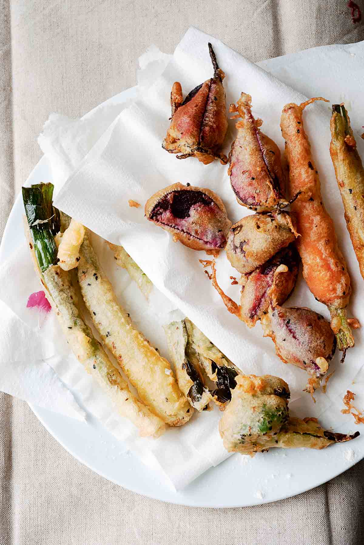 Vegetable tempura of zucchini, beets, carrots, squash on a paper towel on a plate