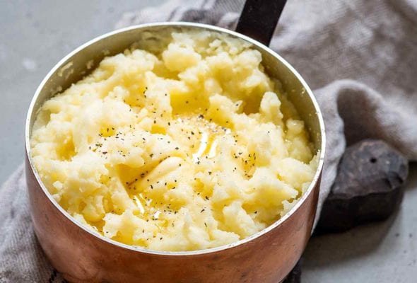 A copper pot with garlic mashed potatoes inside