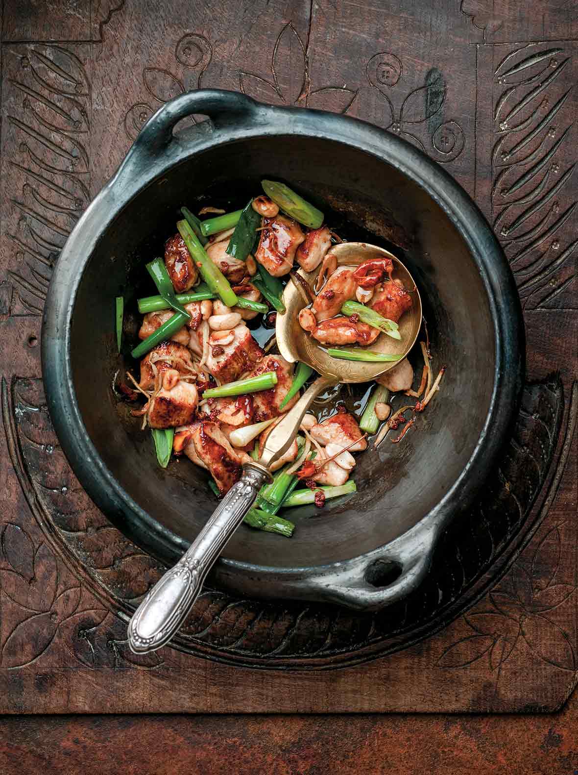 Black pottery bowl filled with the Chinese dish gung bao chicken
