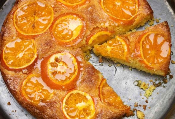 A cut satsuma orange cake in a round baking sheet