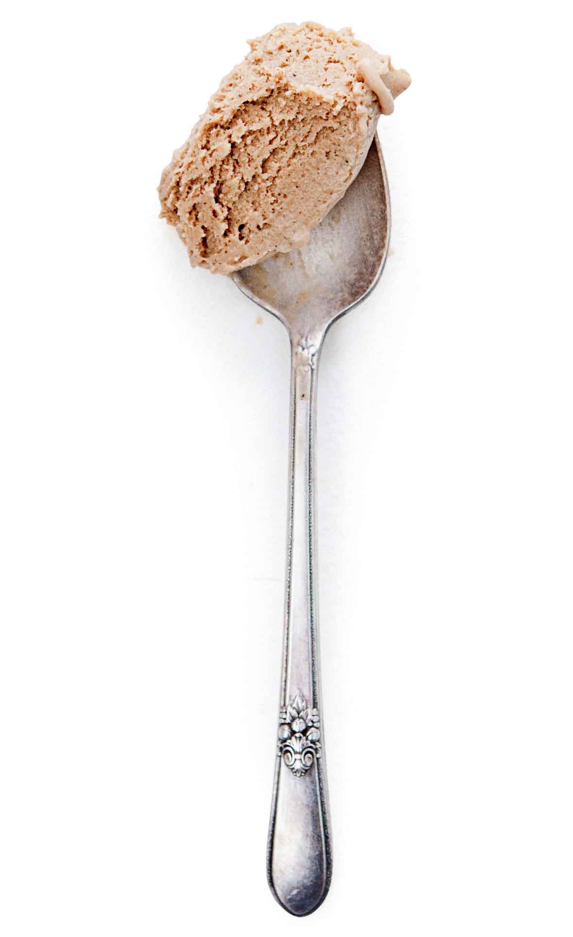 A scoop of black coffee ice cream on a silver spoon.