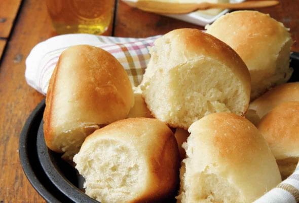 A bowl lined with a napkin and filled with pull-apart rolls