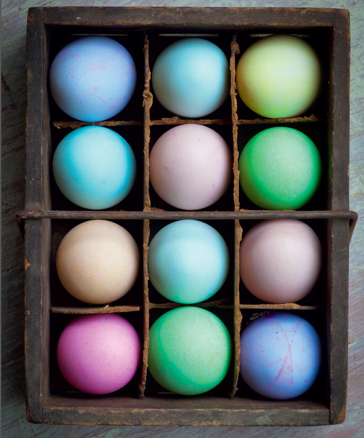 A crate filled with an assortment of dyed easter eggs.
