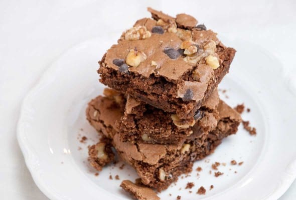 Three Passover brownies stacked on top of each other on a white plate.
