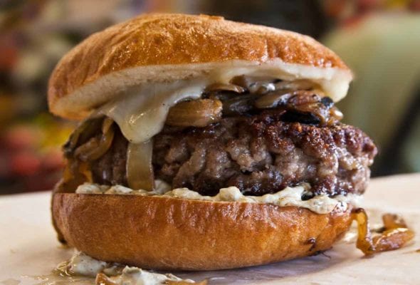 Big fat juicy burger with caramelized onions, melted cheese, and a toasted hard roll