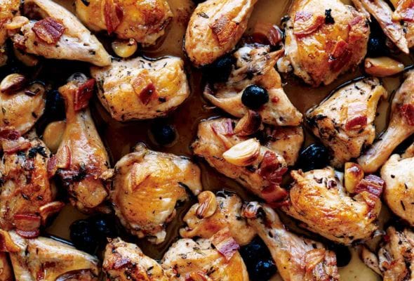 Tray of roast chicken pieces with pancetta, olives, and garlic cloves