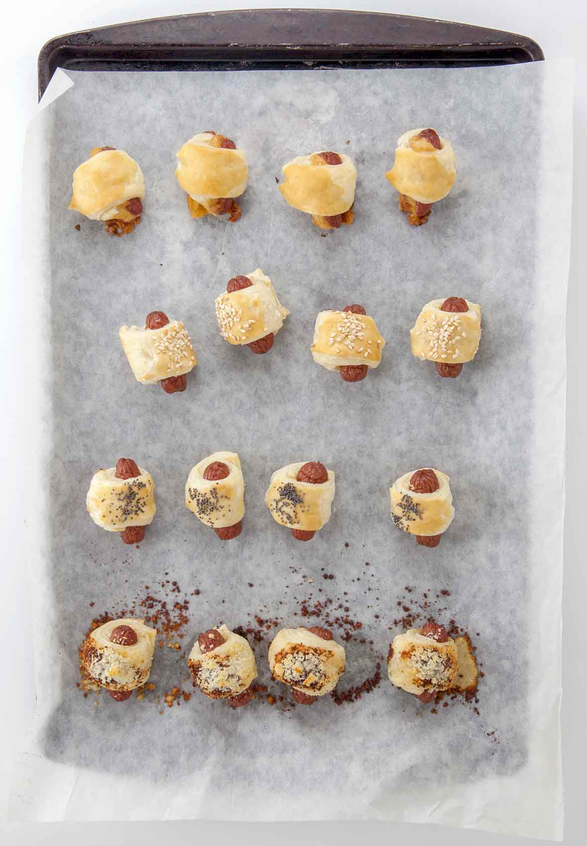 17 mini hog dogs wrapped in puff pastry on a parchment lined baking sheet