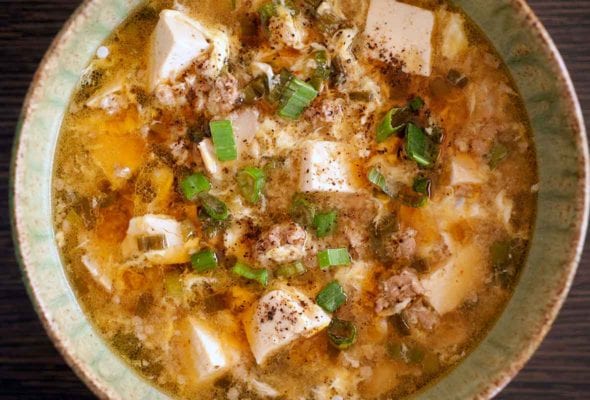A ceramic bowl filled with hot and sour soup.