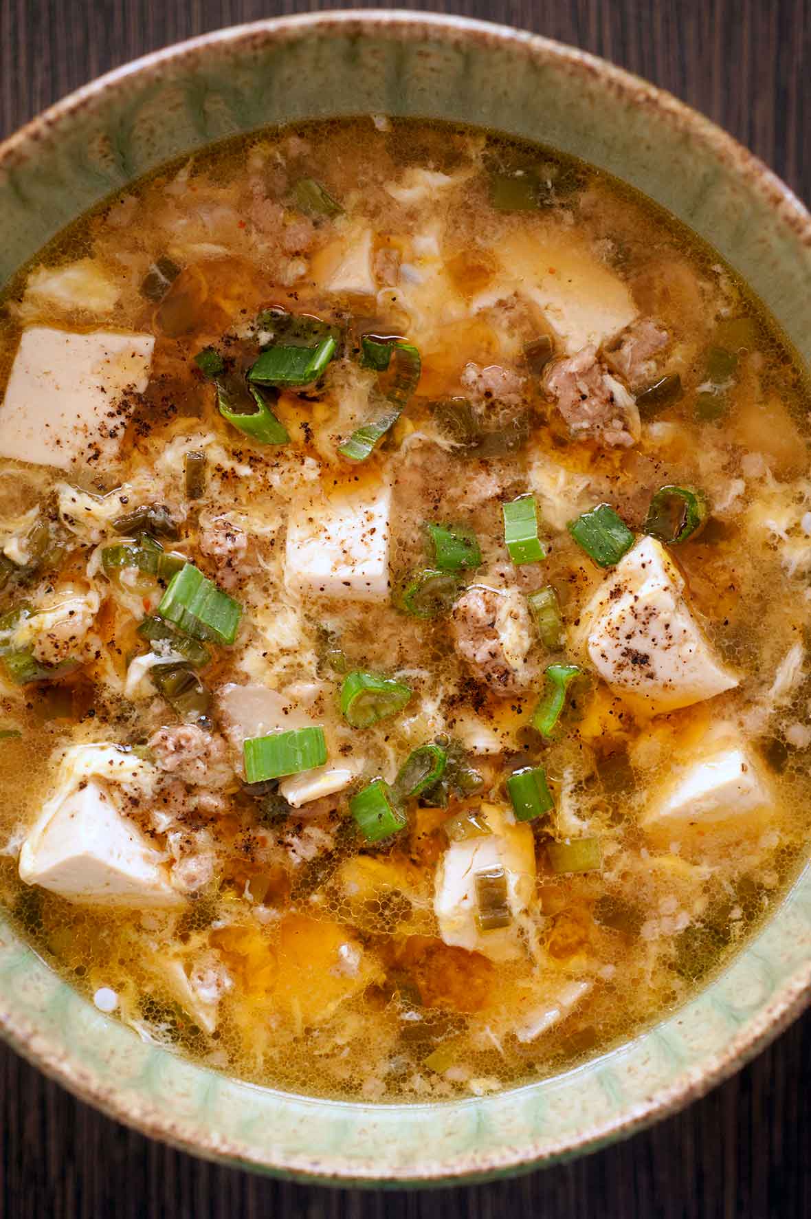 A ceramic bowl filled with hot and sour soup.