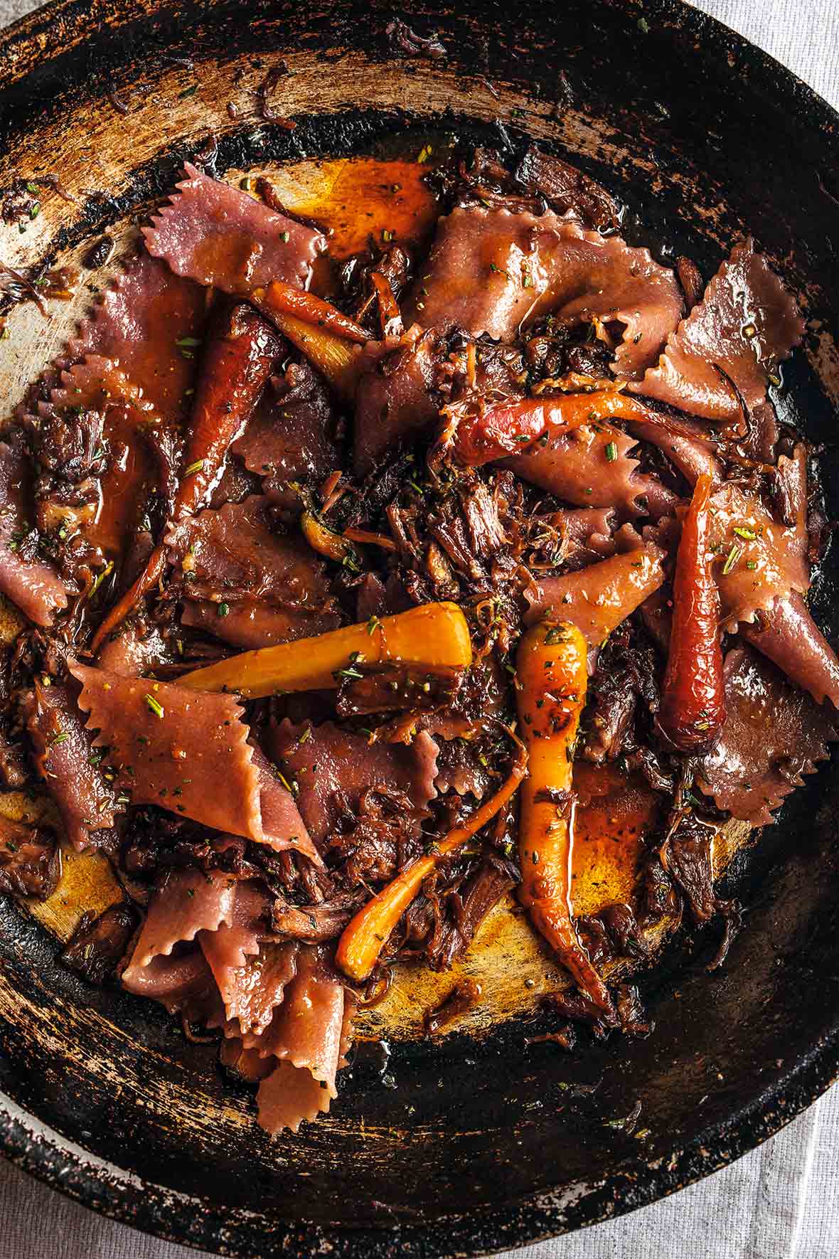 Skillet with shredded braised beef with red wine pasta and carrots