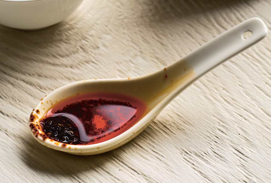 A soup spoon filled with chile oil and dried chiles.