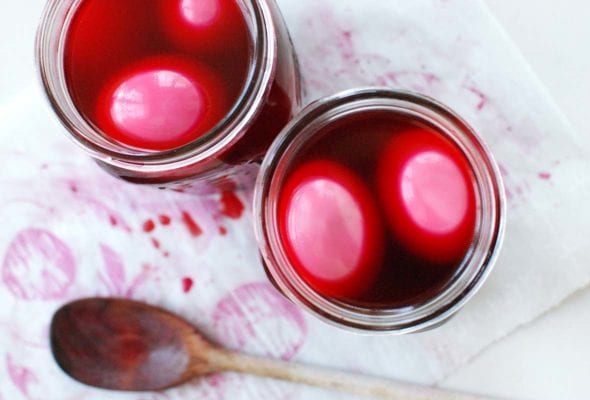 Two Mason jars filled with pickled eggs in beat brine