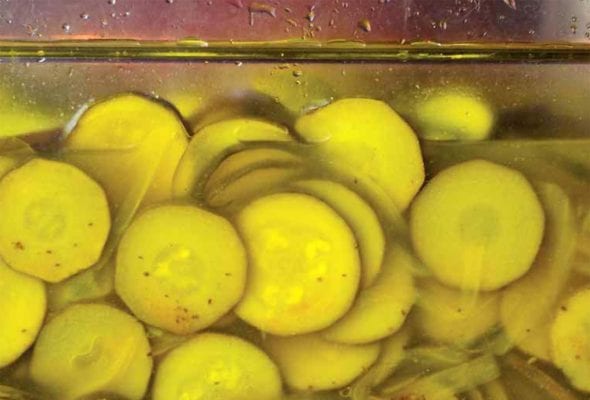 A close up view of a full jar of pickled zucchini.