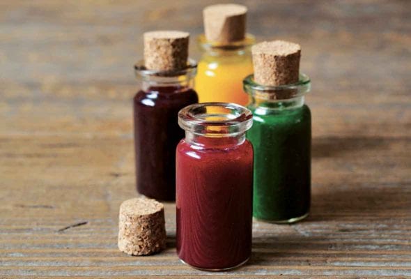 Four vials of natural food coloring--red, purple, yellow, and green