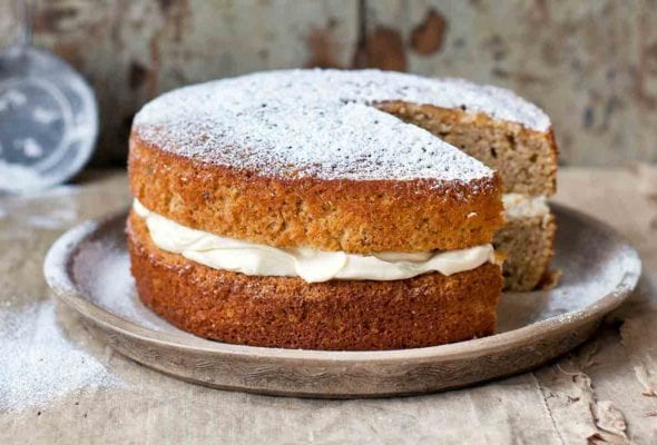 A maple parsnip cake with mascarpone frosting between the layers on a grey plate.