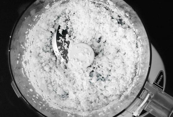 A food processor bowl with riced cauliflower